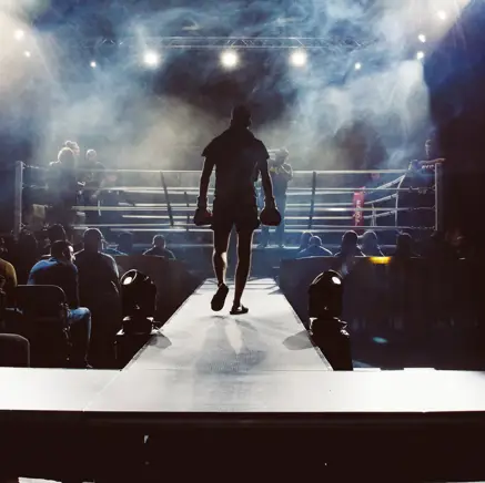 man standing and walking going on boxing ring surrounded with people